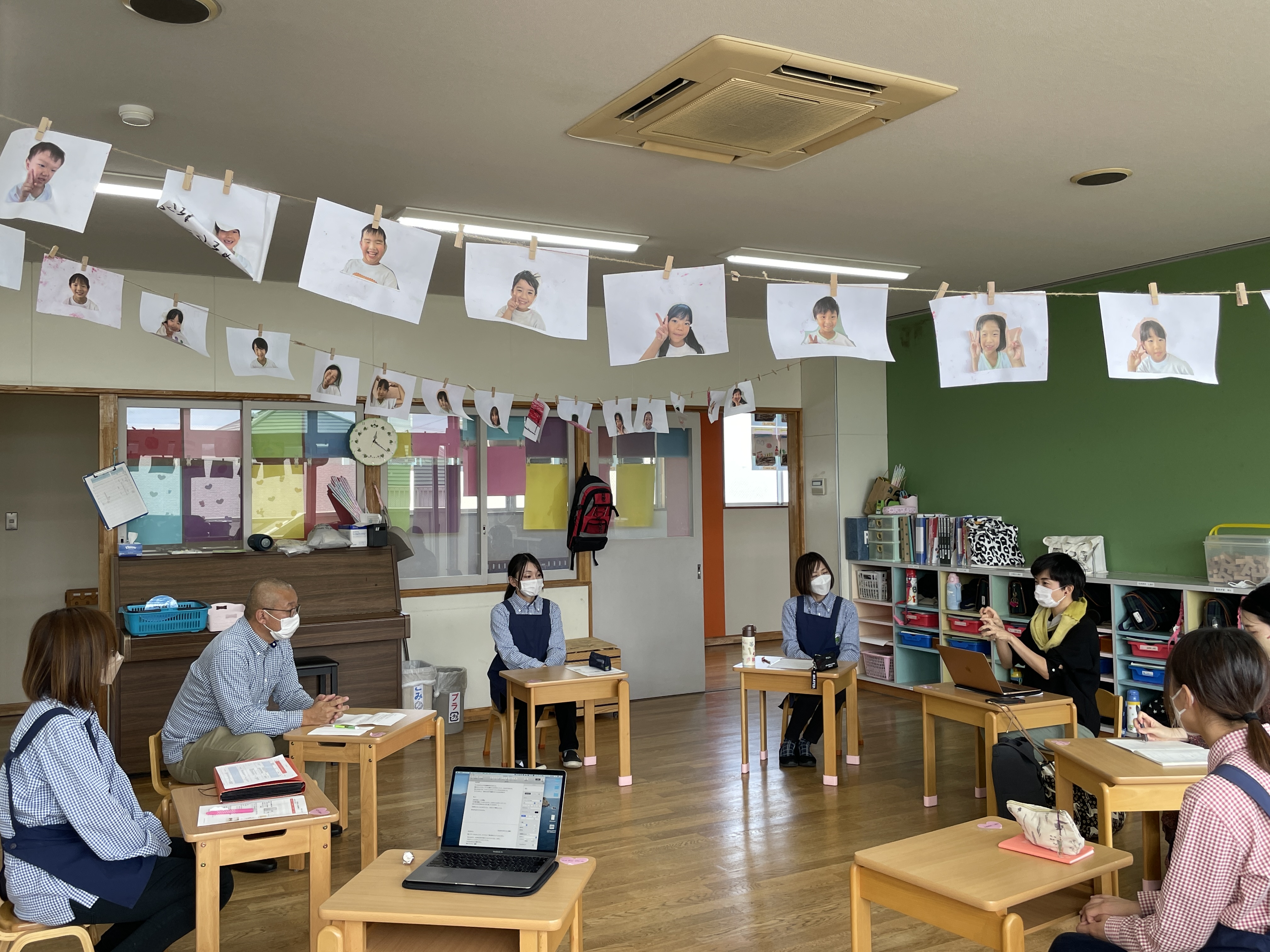 子どもたちの写真が飾られた部屋でのミーティング